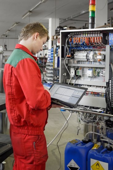 Elektrotechnik s notebookem u průmyslového rozvaděče